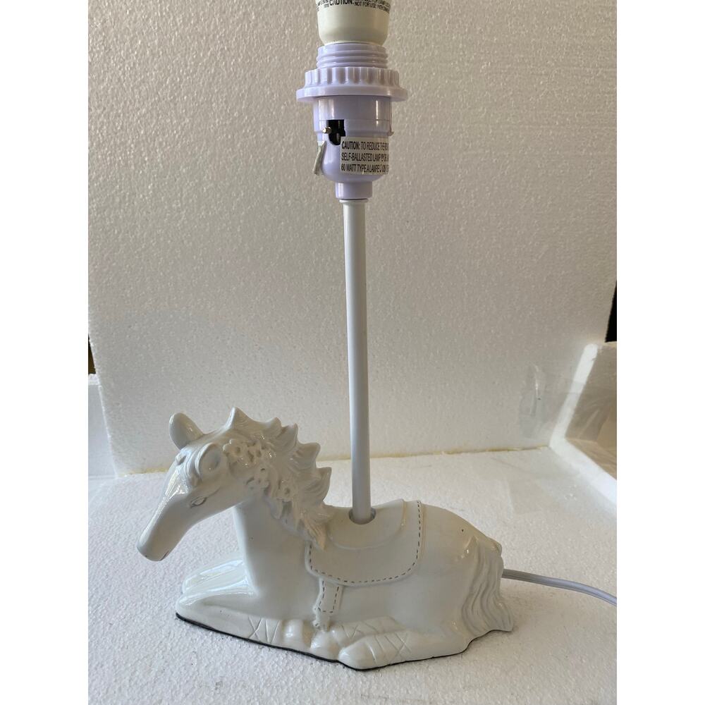 Horse table lamp by Circo Features a white like a lying carousel horse.